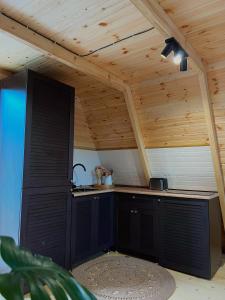 Sun House في باتومي: مطبخ في منزل بسقف خشبي