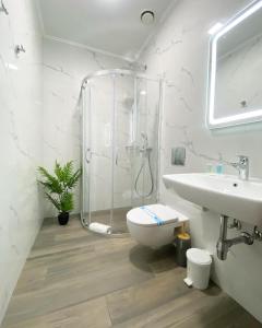 a bathroom with a shower and a toilet and a sink at Grand Christer Hotel in Kyiv