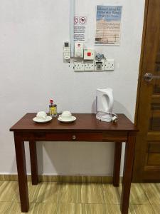 a wooden table with two plates on top of it at Perhentian Mama's in Perhentian Island