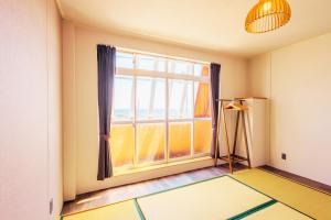 Habitación vacía con ventana grande y trípode en 南知多Seaside Villa en Minamichita