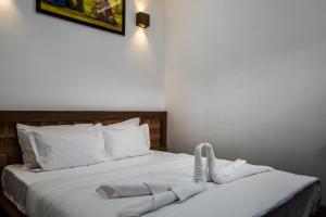 1 dormitorio con 1 cama con toallas en Kanasu StayHome, en Chikmagalur