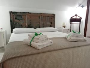 a bedroom with a bed with towels on it at Maison Chèrie in Parabita