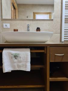 y baño con lavabo blanco y espejo. en Agriturismo Corte degli Ulivi, en Capoterra