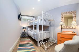 a childs bedroom with a white bunk bed and a chair at Apartment West in Whitby