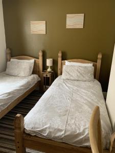 a bedroom with two twin beds and a chair at Oakwell Guest House in Bridlington