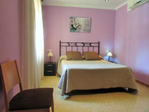 a bedroom with a bed with purple walls and a chair at Hostal Can Bassalis in Pals