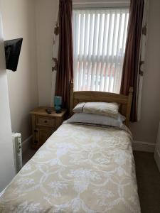 a bedroom with a bed and a window with blinds at Oakwell Guest House in Bridlington