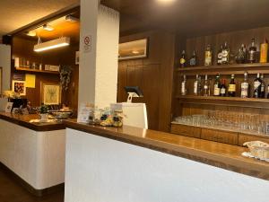 eine Bar mit einer Theke mit Gläsern und Flaschen Alkohol in der Unterkunft Hotel Alle Tre Baite in Santa Caterina Valfurva