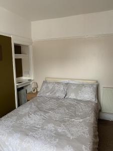 1 dormitorio con 1 cama con edredón blanco en Oakwell Guest House, en Bridlington