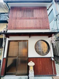 una pequeña casa con techo rojo y ventana en 天王寺駅から徒歩7分, en Osaka