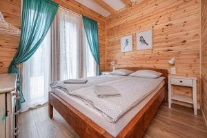 - une chambre avec un lit dans une cabane en bois dans l'établissement Apartamenty Kaszuby, à Szymbark