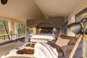 um quarto com uma cama e um sofá num quarto em Mbizane Escarpment Retreat em Schoemanskloof