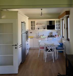 a kitchen with white cabinets and a table with chairs at TRABZON VILLA l in Trabzon