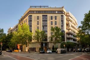 un edificio in una strada cittadina con auto parcheggiate di fronte di Hotel America Barcelona a Barcellona