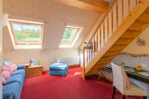 a living room with a blue couch and a staircase at SaarlandTraum Weihermühle in Schmelz