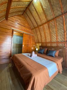 a bedroom with a bed in a room with wooden walls at Batur Bamboo Cabin by ecommerceloka in Kintamani