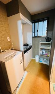 una pequeña cocina con nevera y encimera en 天王寺駅から徒歩7分 en Osaka