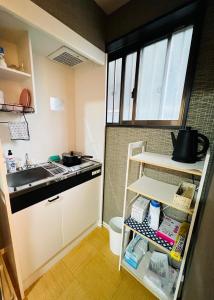 una pequeña cocina con fregadero y estante en 天王寺駅から徒歩7分 en Osaka