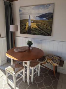 a dining room with a table and chairs and a lighthouse at Badger’s Inlet Devonport in Devonport