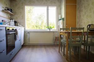 a kitchen with a table with chairs and a window at Norrby Residence,my vintage bnb 