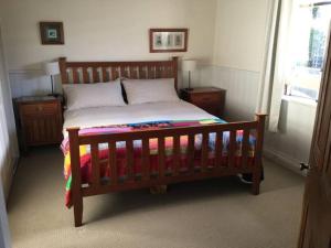 a bedroom with a wooden bed with a wooden frame at Badger’s Inlet Devonport in Devonport