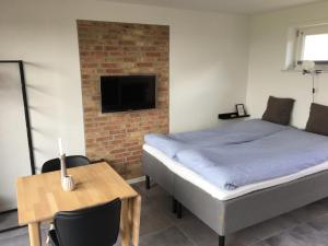 1 dormitorio con cama, mesa y TV en Casa Uno North - Nice appartement for two with sea view, en Farsø