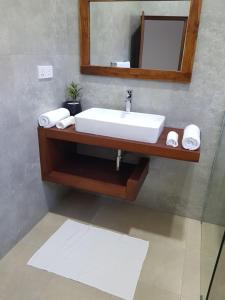uma casa de banho com um lavatório e um espelho em Tortuga Beach Hotel em Paiyagala South