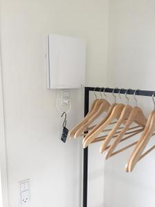a closet with wooden hangers and a lightswitch at Casa Uno North - Nice appartement for two with sea view in Farsø