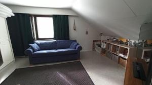 a living room with a blue couch and a window at Talo uima-altaalla in Hämeenlinna