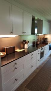 a kitchen with white cabinets and a counter top at Talo uima-altaalla in Hämeenlinna