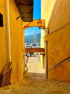 an alleyway between two buildings with a view of a harbor at T3 Sur les Toits de Propriano in Propriano
