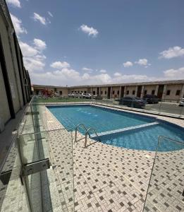 a large swimming pool next to a building at Leen Serviced Apartments in Khamis Mushayt