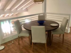 uma sala de jantar com uma mesa de madeira e cadeiras em Villetta nuova giardino 4 lati em Pietrasanta