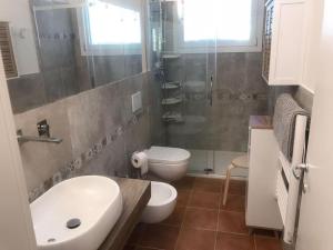 uma casa de banho com um lavatório, um WC e um chuveiro em Villetta nuova giardino 4 lati em Pietrasanta