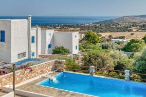 a villa with a swimming pool and a view of the ocean at Lovely Apartment With Shared Pool in Aspro Chorio Paros