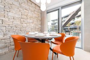- une salle à manger avec une table et des chaises orange dans l'établissement Luxury semi detached villa Smokva 2 - near center and sea - by TRAVELER tourist agency Krk, à Krk