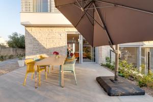 une terrasse avec une table, des chaises et un parasol dans l'établissement Luxury semi detached villa Smokva 2 - near center and sea - by TRAVELER tourist agency Krk, à Krk