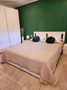 sypialnia z dużym łóżkiem i zieloną ścianą w obiekcie Apartments Sinković w Dubrowniku