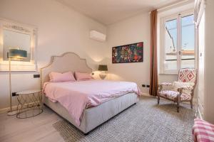 - une chambre avec un lit, une chaise et une fenêtre dans l'établissement La Casa di Ely, à Lido di Camaiore