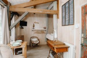 a room with a table and chairs and a room with a window at Le Cabanon doré, Suite SPA et nature chez Ivona Vacances in Le Teich