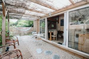 a screened in porch with a table and chairs at Le Cabanon doré, Suite SPA et nature chez Ivona Vacances in Le Teich