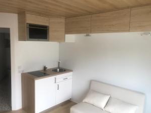 uma pequena cozinha com um sofá e um lavatório em Petit studio sur propriété em Orvault