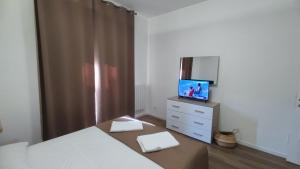 a bedroom with a bed and a tv on a dresser at Appartamento Roma Casa Vacanza Sea House Rome 50 metri dal mare in Lido di Ostia