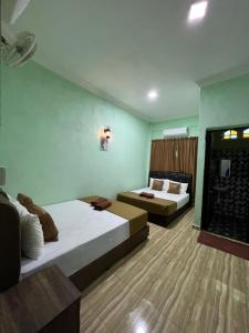 a hotel room with two beds and a window at Perhentian Mama's in Perhentian Islands