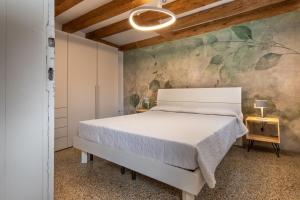a bedroom with a white bed and a painting on the wall at Ca' Rampani @Venice in Venice