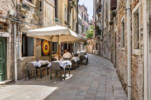 an empty street with tables and chairs in an alley at Ca' Rampani @Venice in Venice