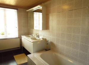 y baño con lavabo, bañera y espejo. en Hof ter Harte, en Ypres