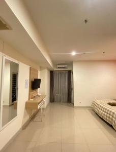 a bedroom with a bed and a desk and a television at LagoonRoom911 in Pulosirih
