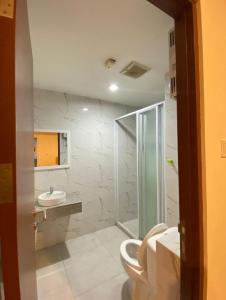 uma casa de banho com um chuveiro, um WC e um lavatório. em LagoonRoom911 em Pulosirih
