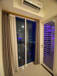 a window with a view of a city at night at LagoonRoom911 in Pulosirih